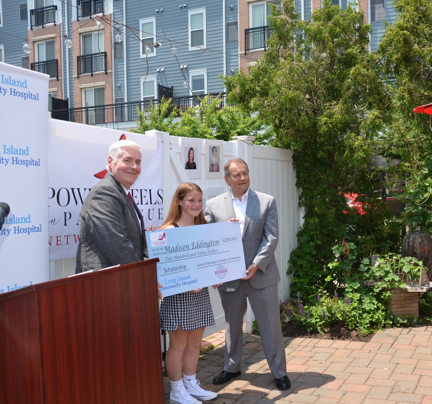 Richard T. Margulis (left) and David Kennedy present Madison Eddington with her $250 scholarship.